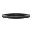 Bred rund BERG Favorit InGround trampolin uden net, grå kantpude og sort dug, set fra siden mod hvid baggrund