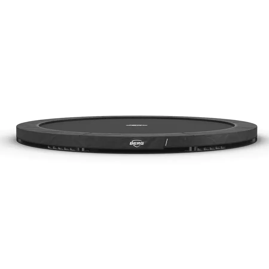 Lav, rund BERG Champion InGround trampolin uden sikkerhedsnet med mørkegrå polstring, set fra siden på hvid baggrund