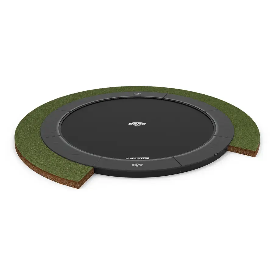 Rund BERG Elite FlatGround trampolin uden net, grå kantpude i niveau med græsset i et snit af jord og græs